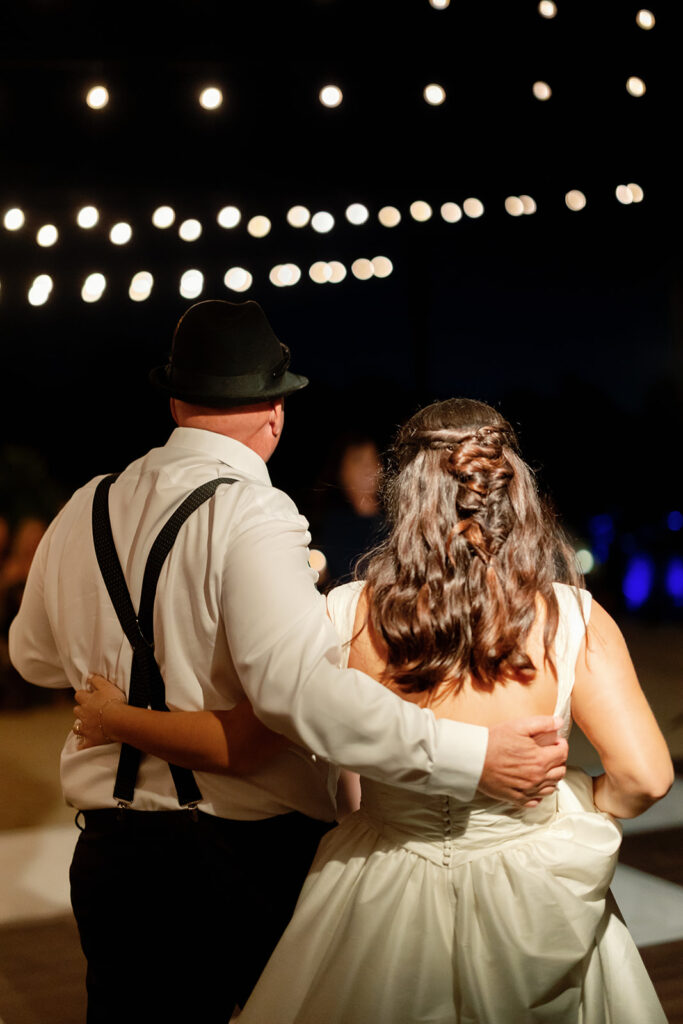 Bride watching the reception with her father.
