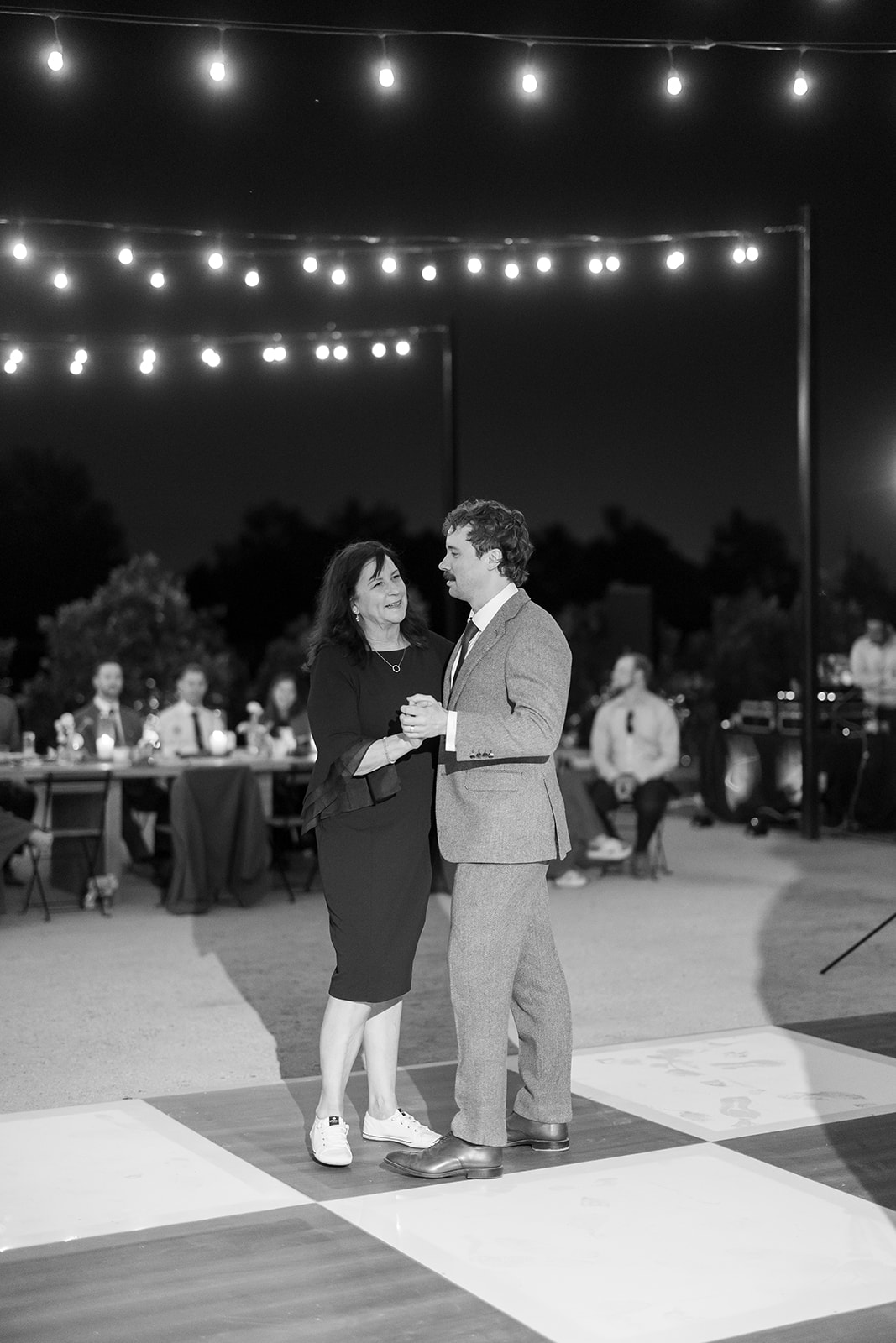 Black and white photo of the groom dancing with his mother.