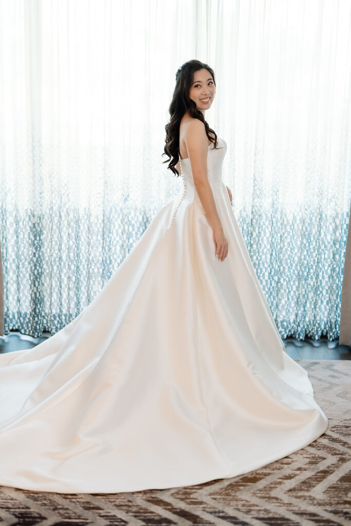 Bride posing in front of a window for indoor portraits.