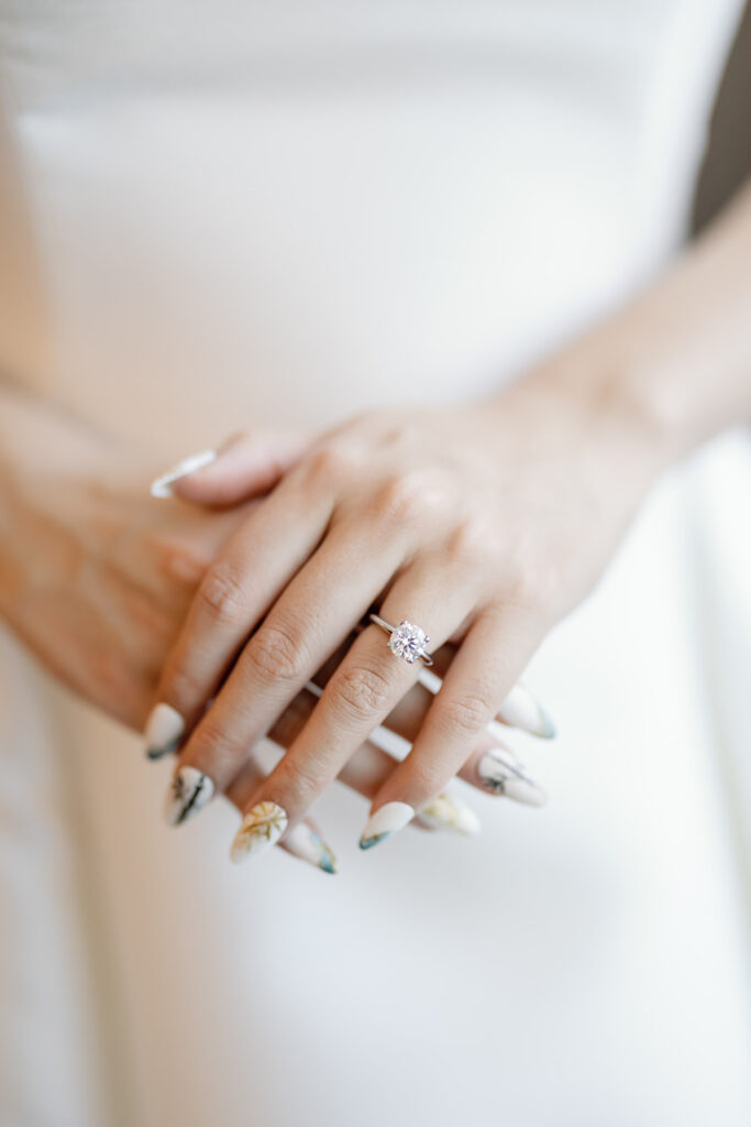 Close up shot of a brides hands showing off her wedding ring.