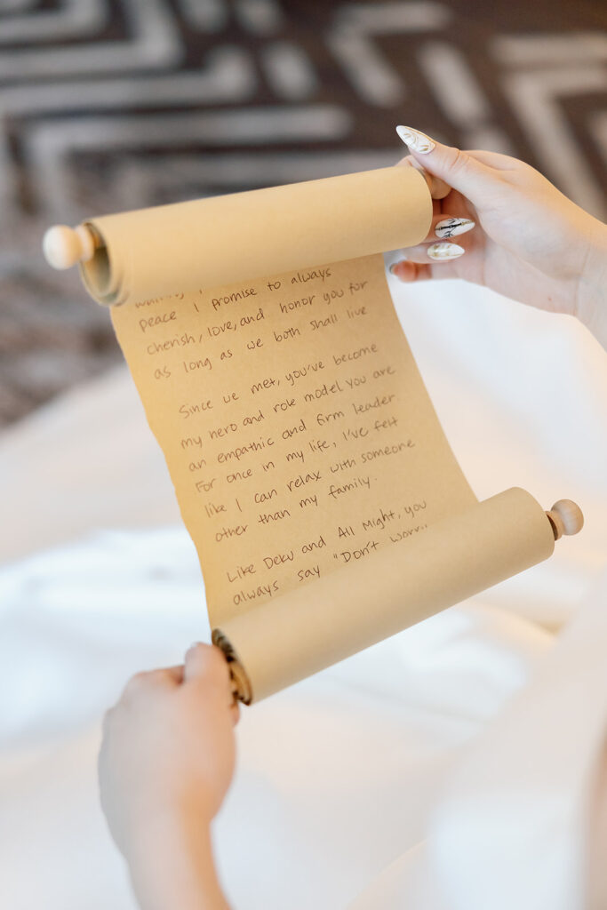 Bride reading over her vows which are written on a big scroll of paper.