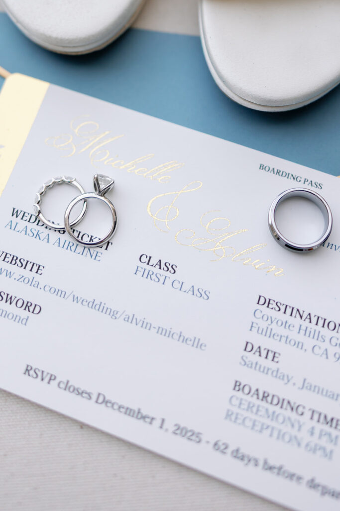 Wedding rings and boarding pass inspired invitation suite for a Coyote Hills Golf Course wedding.