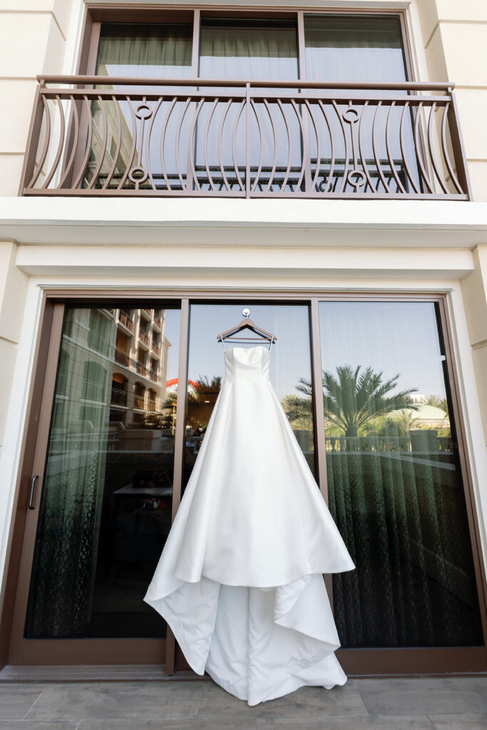 Brides wedding dress hanging from Westin Hotel.