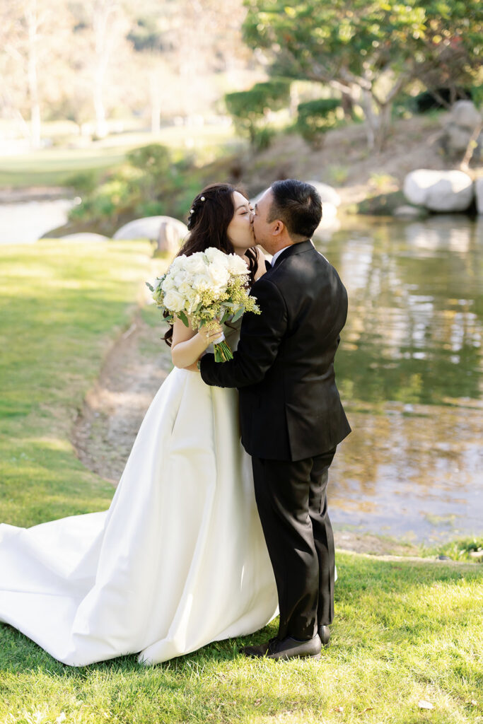 Bride and groom kissing after their first look at Coyote Hills Golf Course,