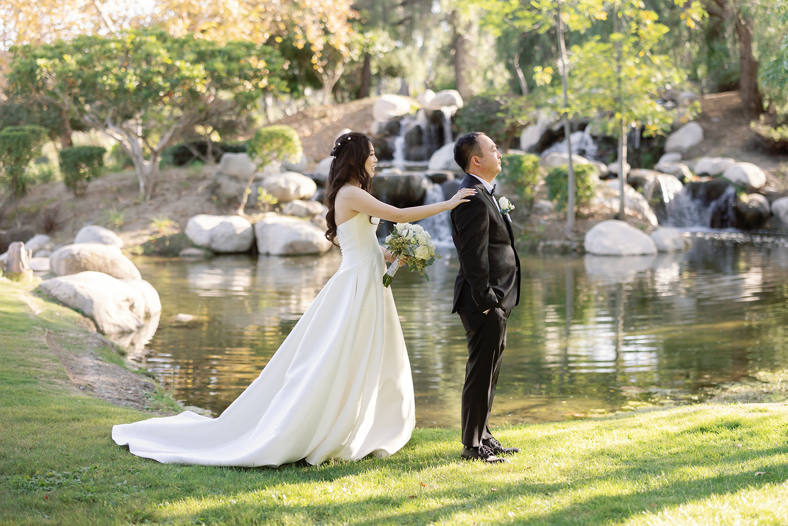 Bride tapping the groom on the shoulder during their first look at Coyote Hills Golf Course.