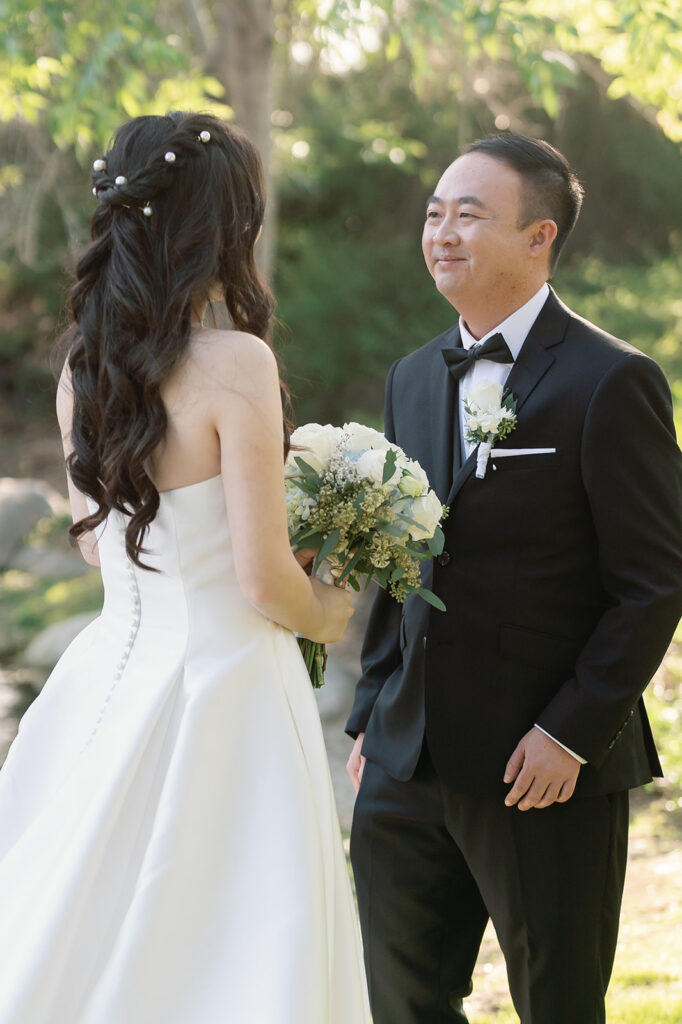 Groom smiling at the bride during their first look.