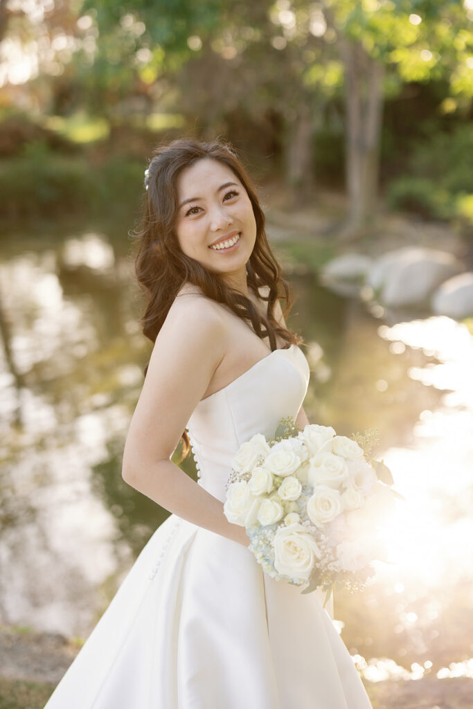 Outdoor bridal portrait during golden hour in front of a lake.