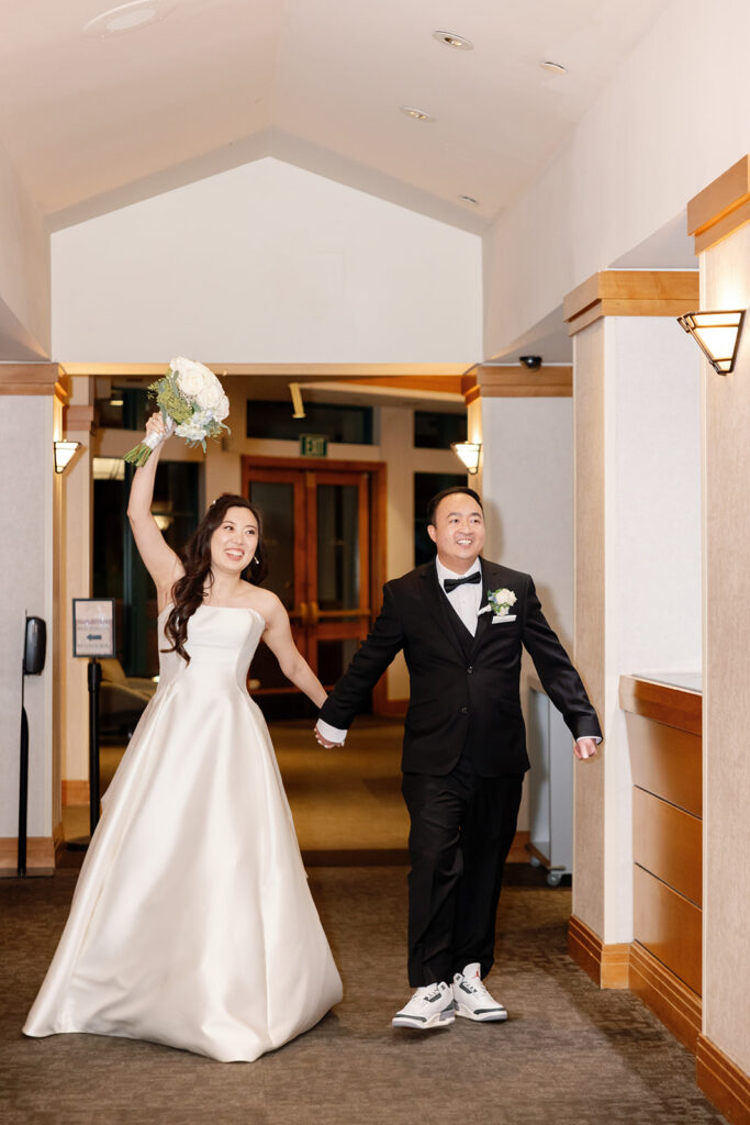 Bride and groom entering their indoor Coyote Hills Golf Club wedding reception in the Vista Falls Pointe Ballroom.

