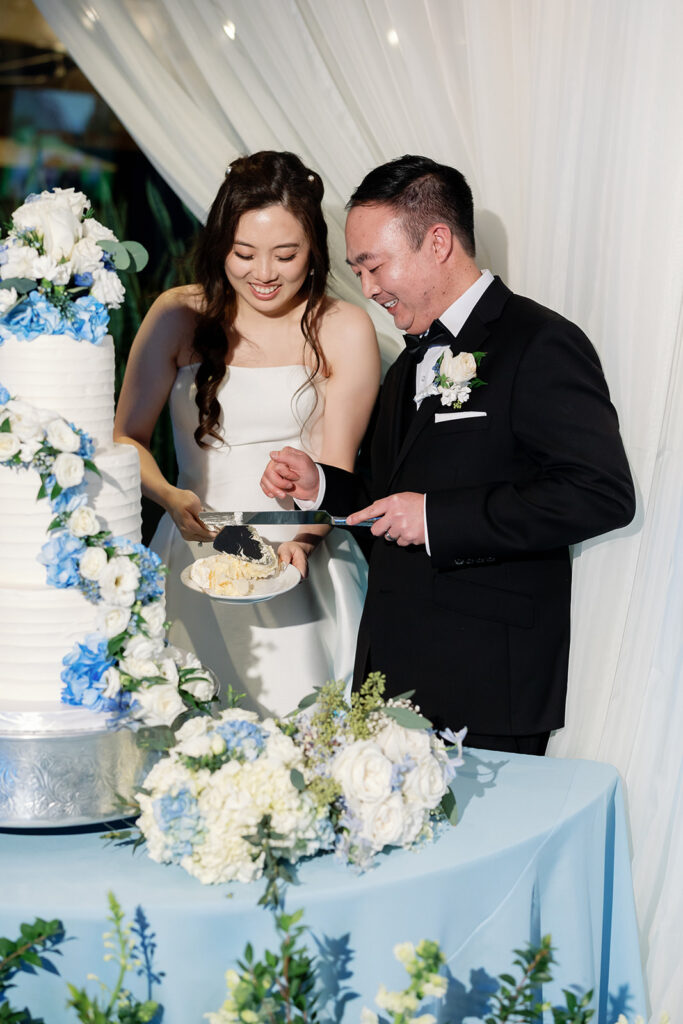 Bride and groom cutting into their wedding cake.