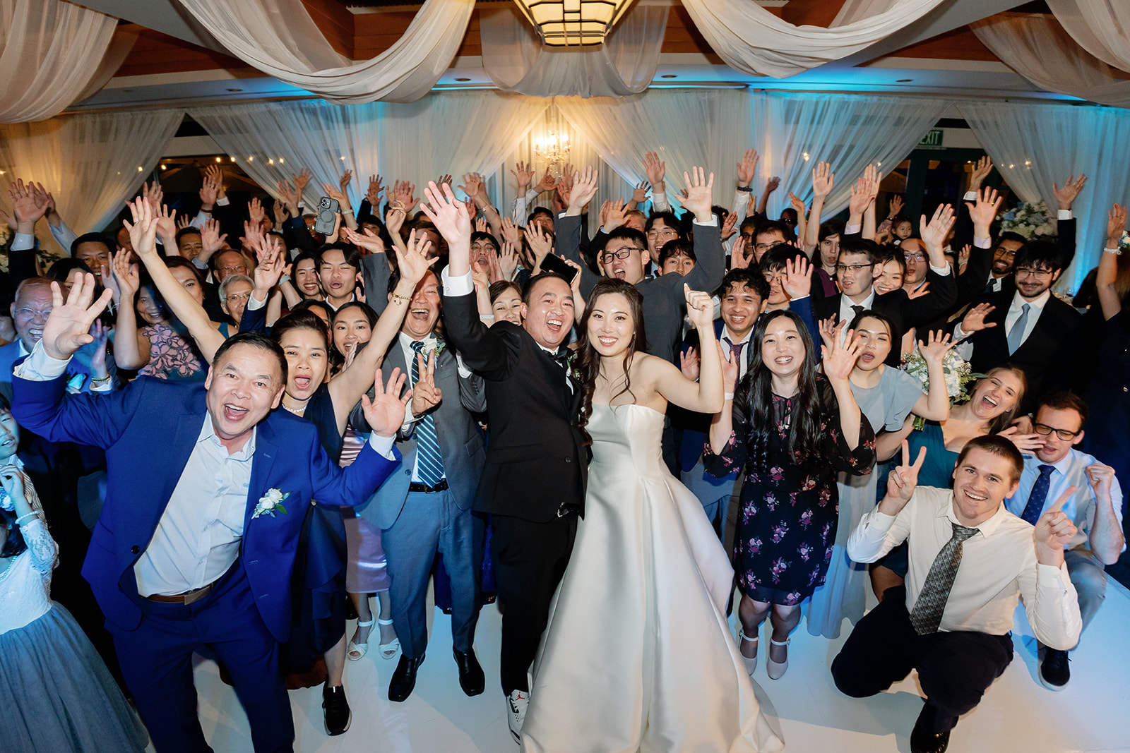 Large group shot of guests during an indoor Coyote Hills Golf Club wedding reception in the Vista Falls Pointe Ballroom.
