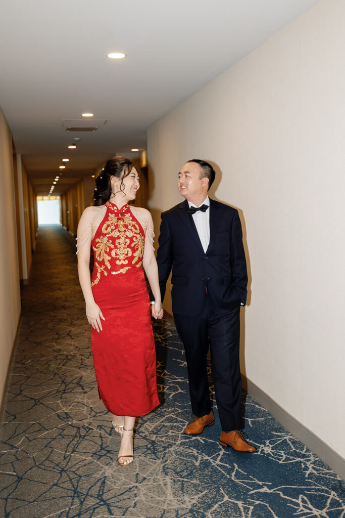Bride and groom walking down the hall at their hotel.
