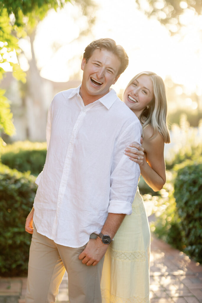 Couple smiling and laughing together during golden hour portraits after their Santa Barbara proposal.