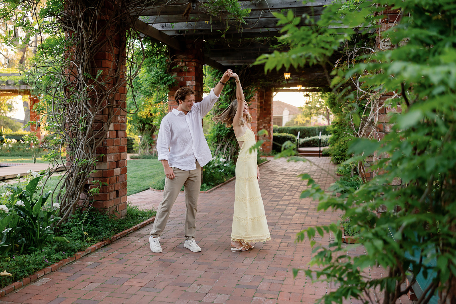 Couple twirling together under the arbor during their El Encanto engagement photos.