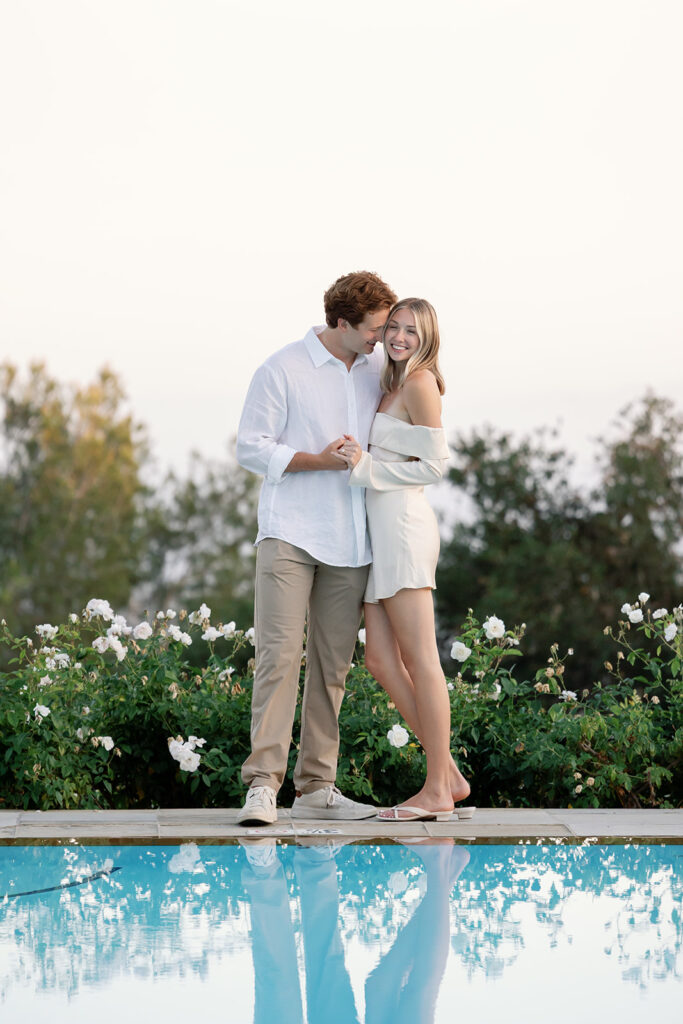 Couple posing by the zero-edge outdoor pool at El Encanto after their Santa Barbara proposal.