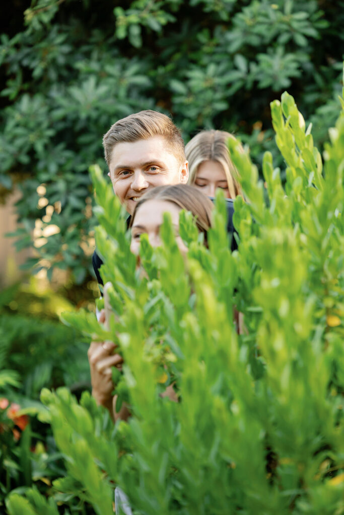 Siblings hiding in the greenery before a proposal.