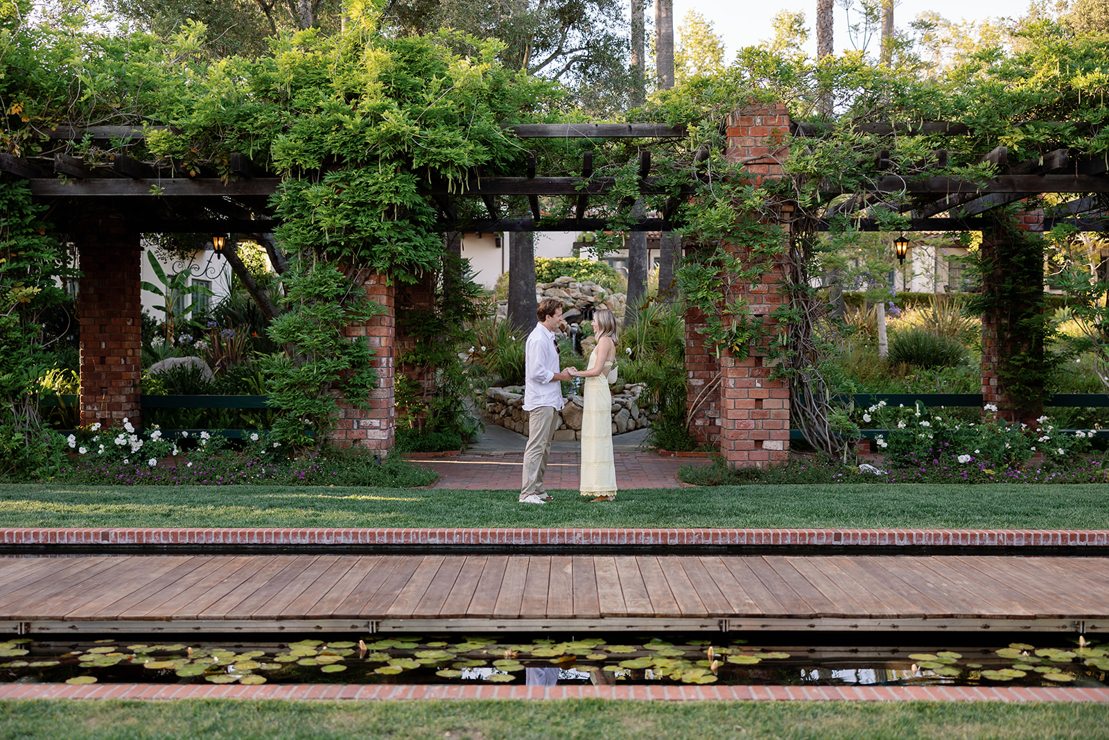 Santa Barbara proposal at El Encanto with a couple standing by the Arbor and Lily Pond surrounded by greenery.
