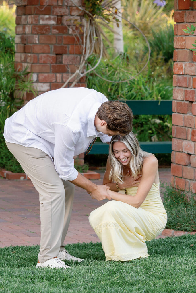 Couple laughing together after a proposal near the Arbor and Lily Pond at El Encanto.