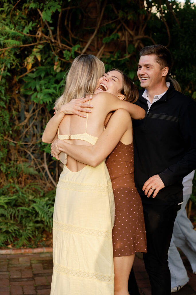 Bride-to-be hugging a sibling after her surprise proposal at El Encanto in Santa Barbara.