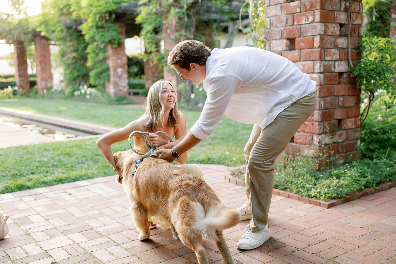 Newly engaged couple greeting their dog by the Lily Pond at El Encanto in Santa Barbara.