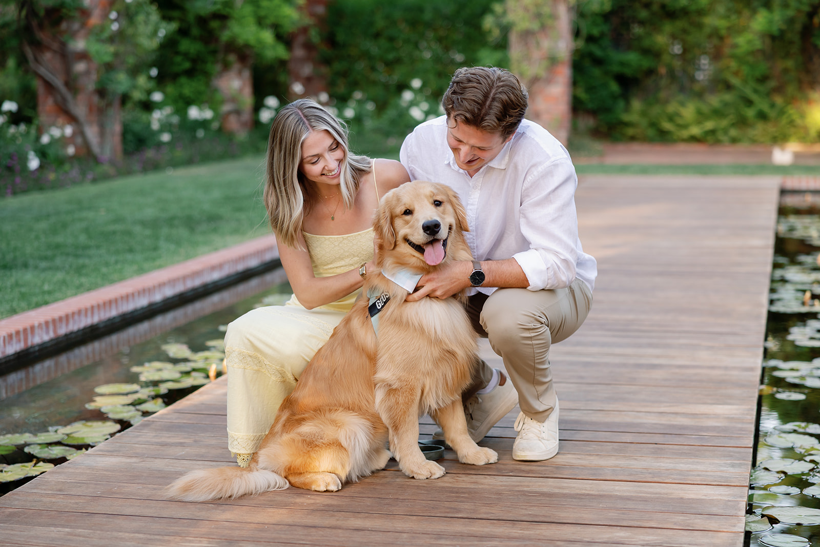 Newly engaged couple posing with their dog by the Lily Pond at El Encanto in Santa Barbara.