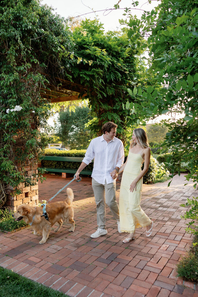Newly engaged couple walking with their dog after their Santa Barbara proposal at El Encanto.