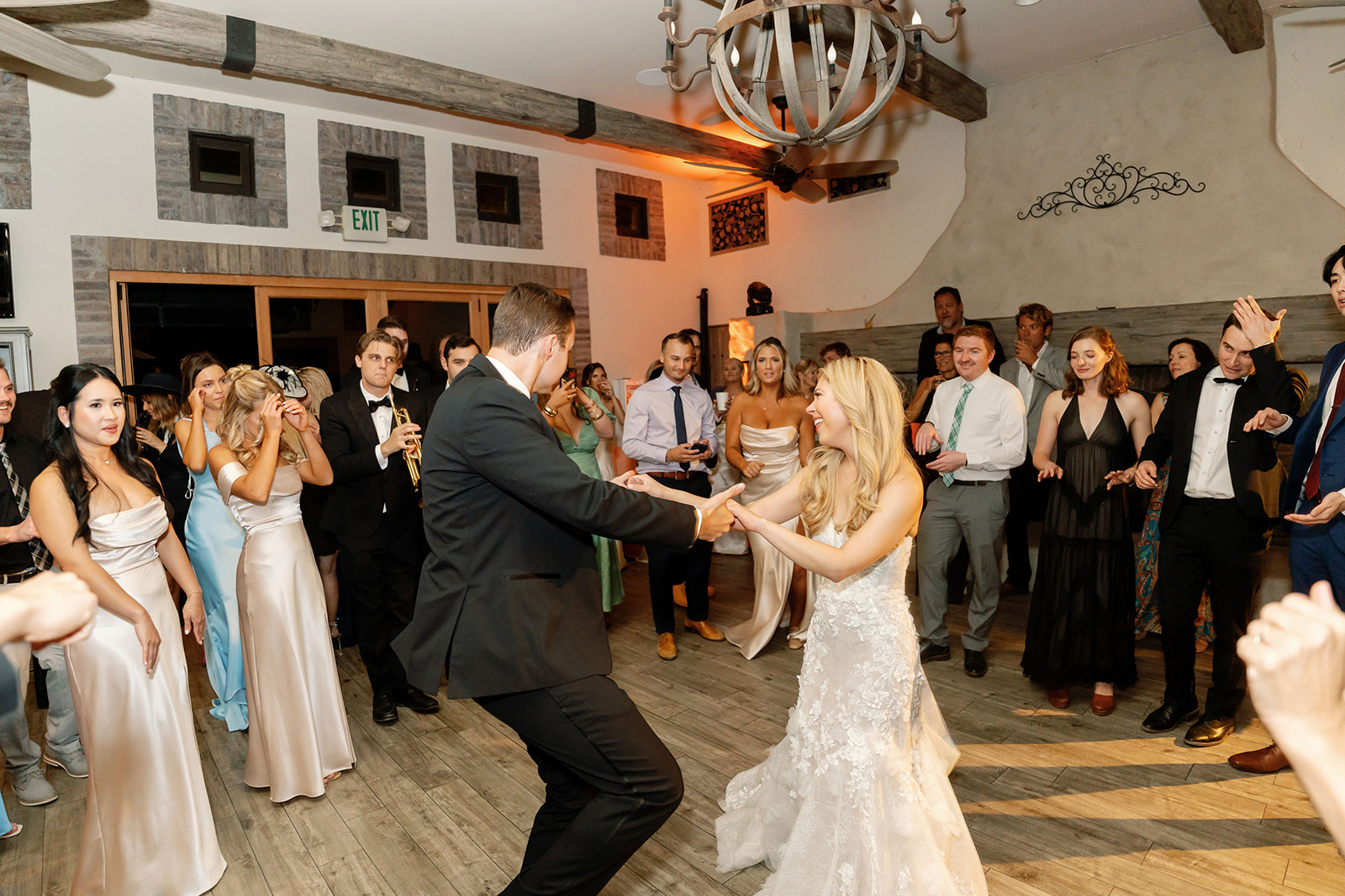 Bride and groom dancing indoors with guests during their Lake Oak Meadows wedding reception.