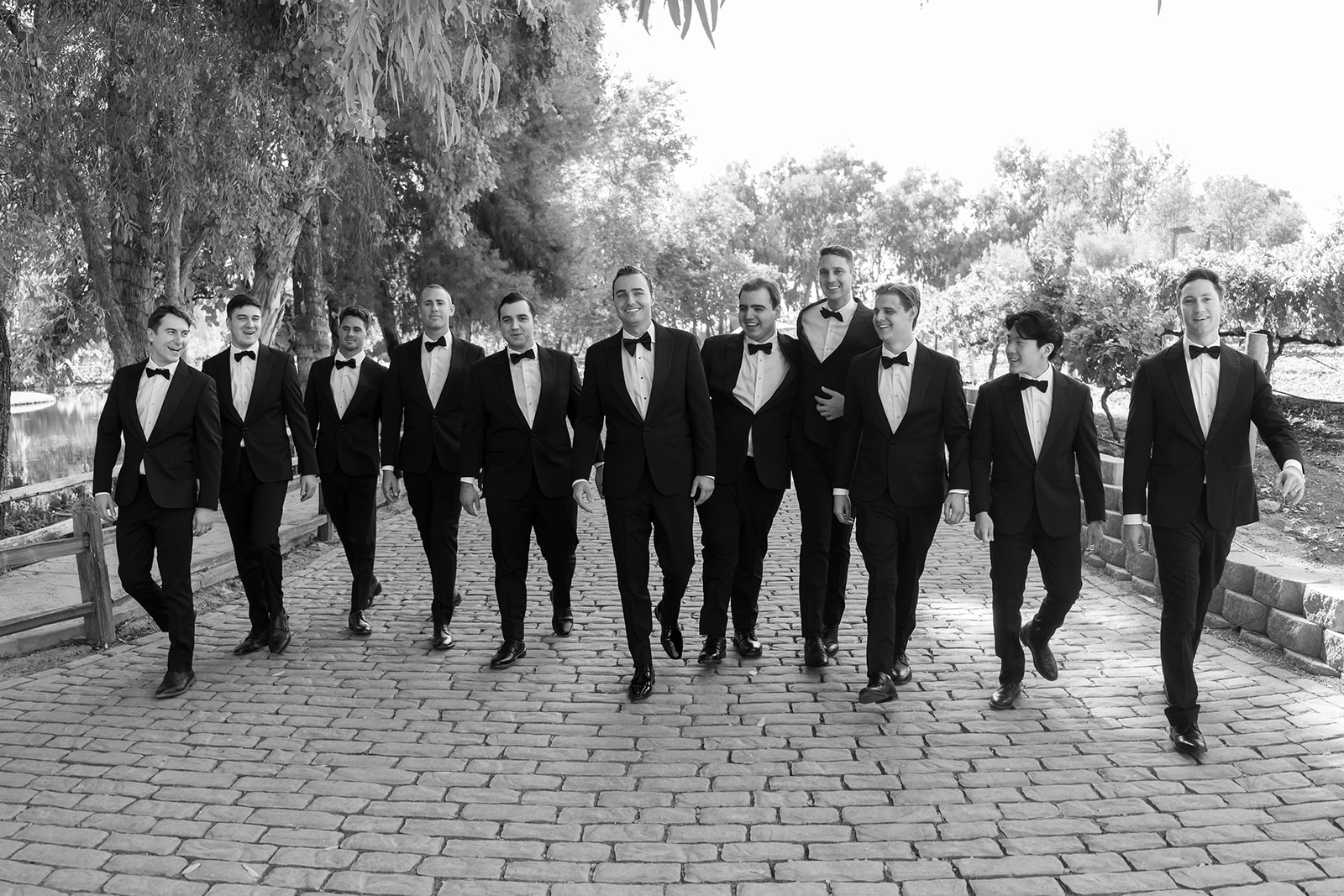 Groom walking with groomsmen in black tuxes before a Lake Oak Meadows wedding in Temecula California.