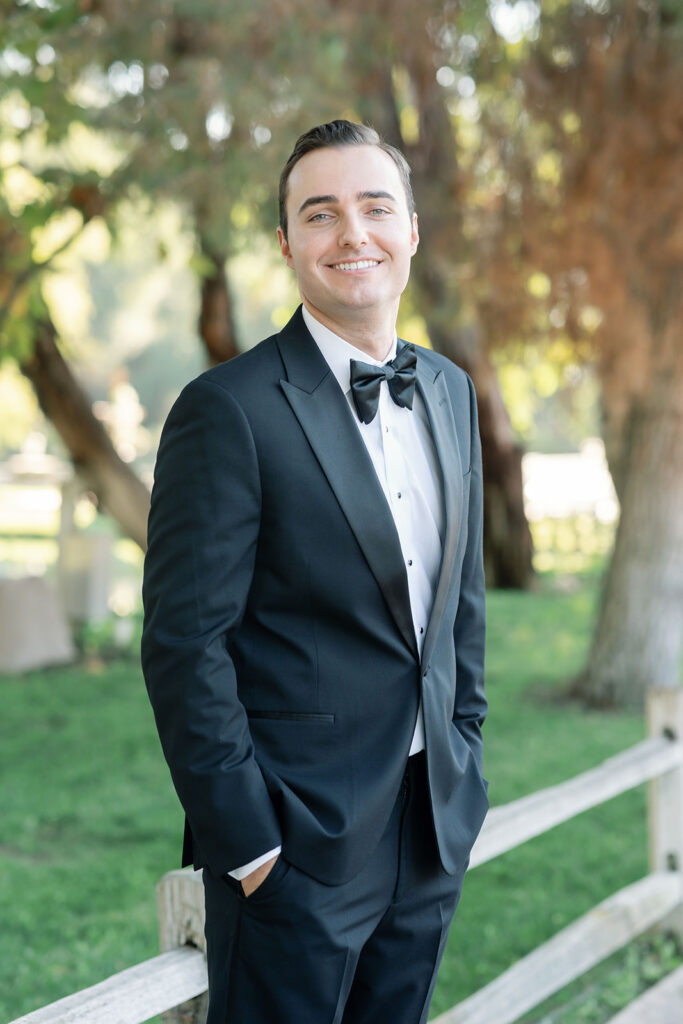 Groom wearing a black tux for portraits outside at Lake Oak Meadows in Temecula California.