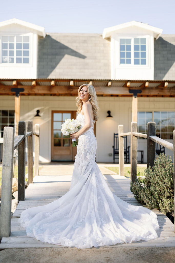 Bride standing on the dock outside the getting ready house at Lake Oak Meadows before her wedding ceremony.