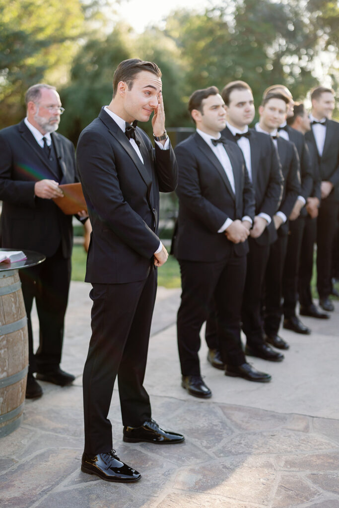 Groom wiping away tears during an emotional Lake Oak Meadows wedding ceremony.
