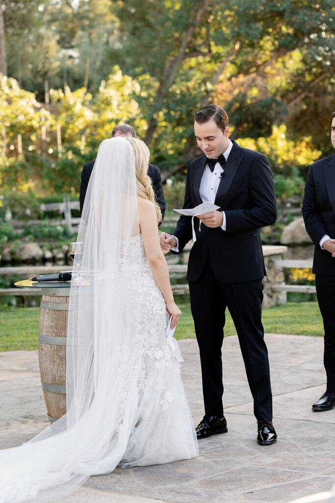 Groom reading vows to bride during a romantic Lake Oak Meadows wedding ceremony.