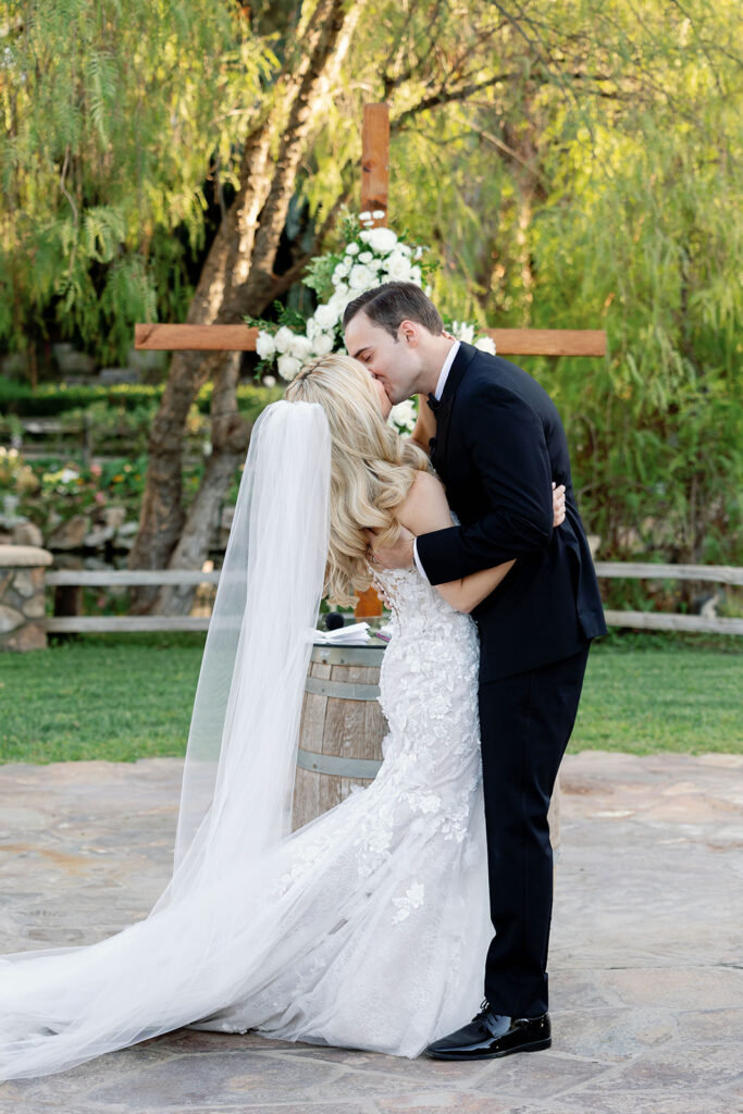 Bride and groom sharing their first kiss during a Lake Oak Meadows wedding ceremony.