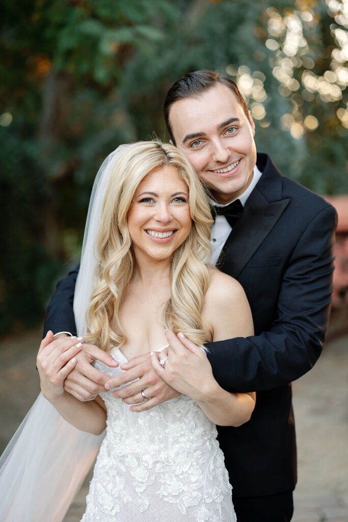 Bride and groom smiling at the camera for their Lake Oak Meadows wedding photos in Temecula.