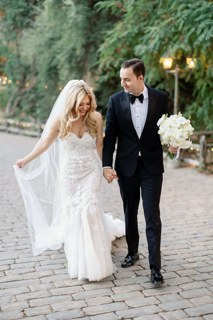 Bride and groom holding hands and walking at Lake Oak Meadows in Temecula.