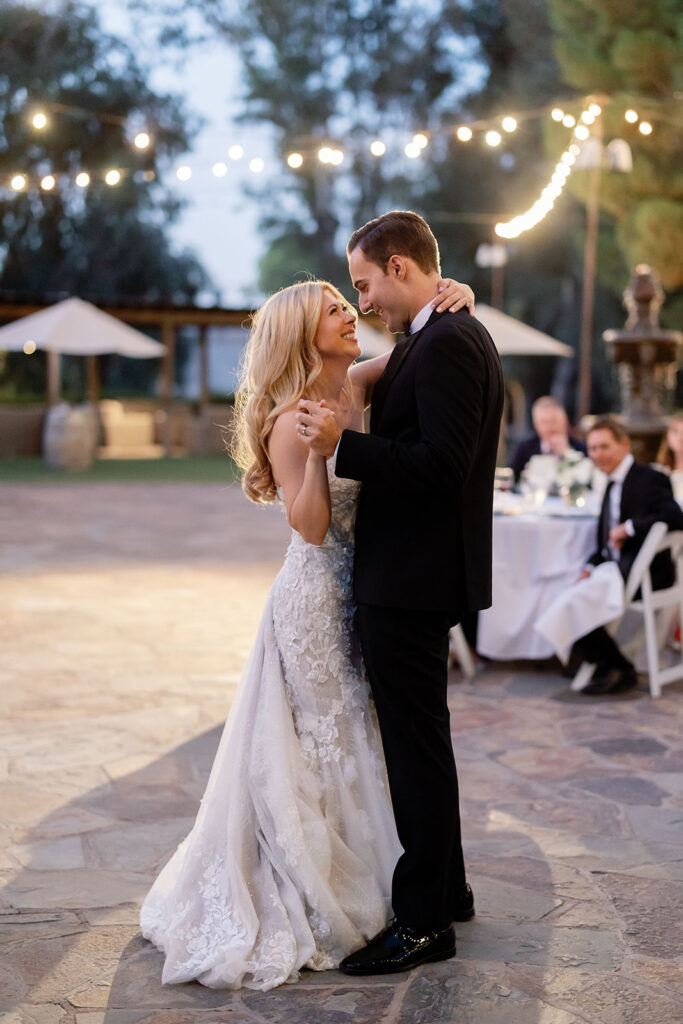 Bride and groom sharing their first dance during an outdoor Lake Oak Meadows wedding reception.