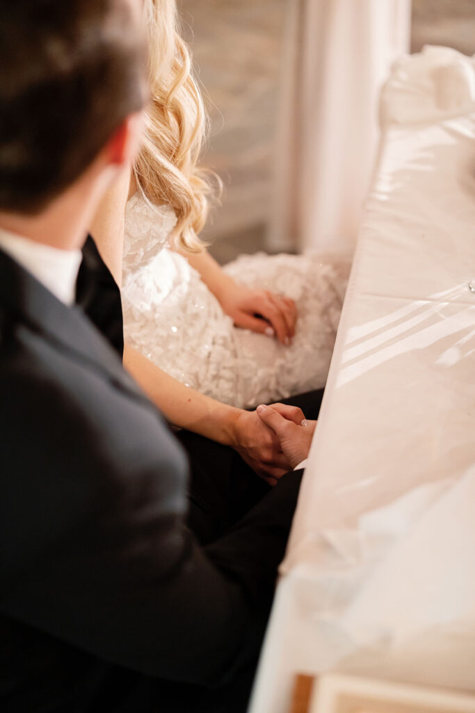 Bride and groom holding hands during a quiet reception moment at their Lake Oak Meadows wedding.