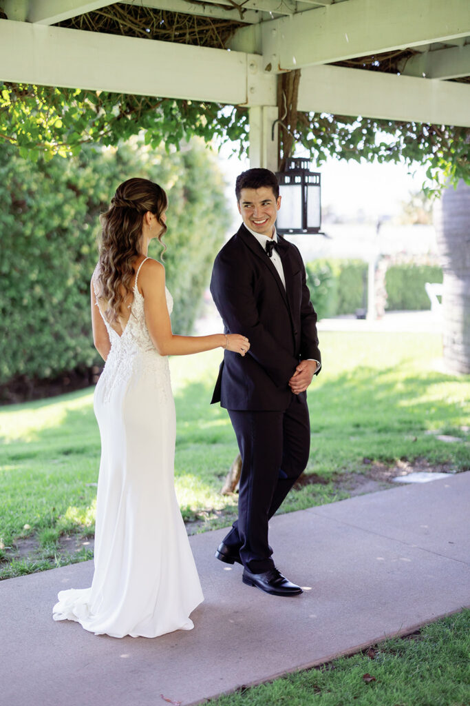 Groom smiling as he turns around to see his bride for their first look.
