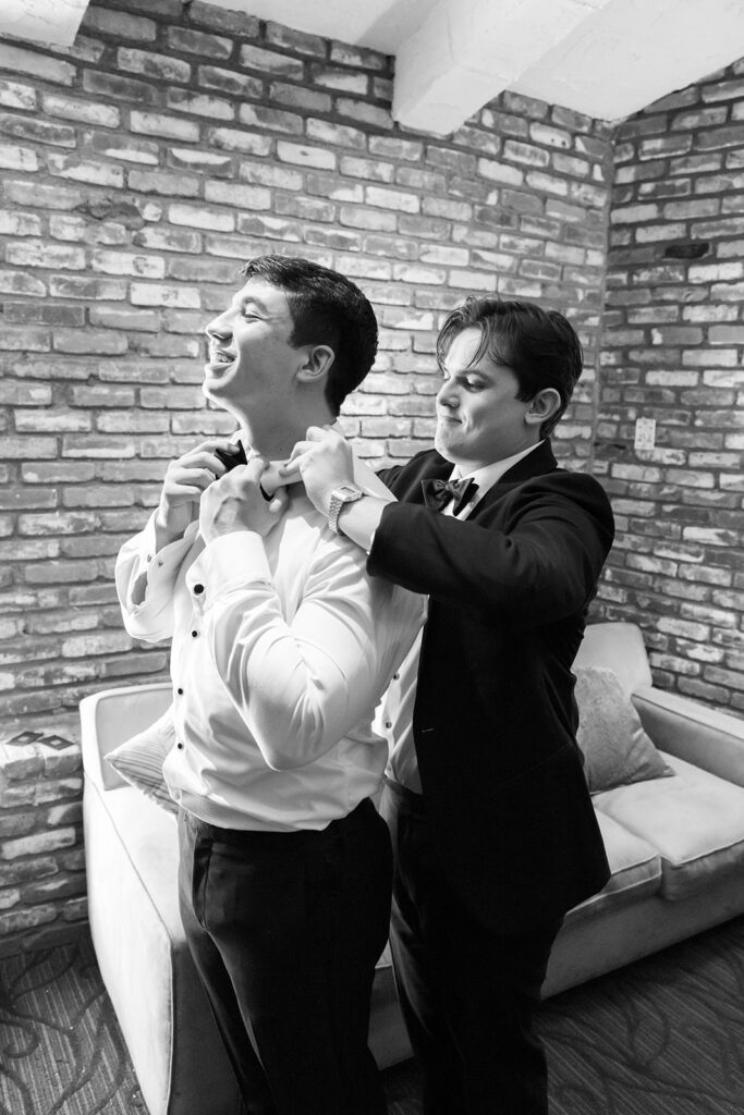 Groom getting help with his bow tie while preparing for a Hyatt Regency Newport Beach wedding.