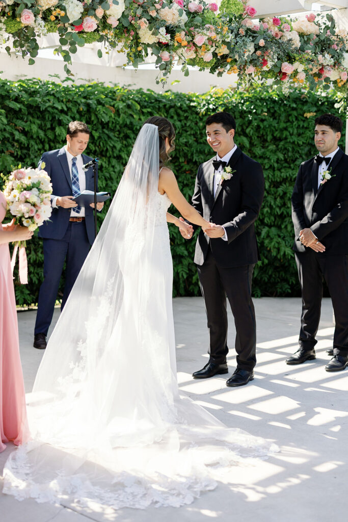 Bride and groom holding hands during their Hyatt Regency Newport Beach Amphitheater wedding ceremony.