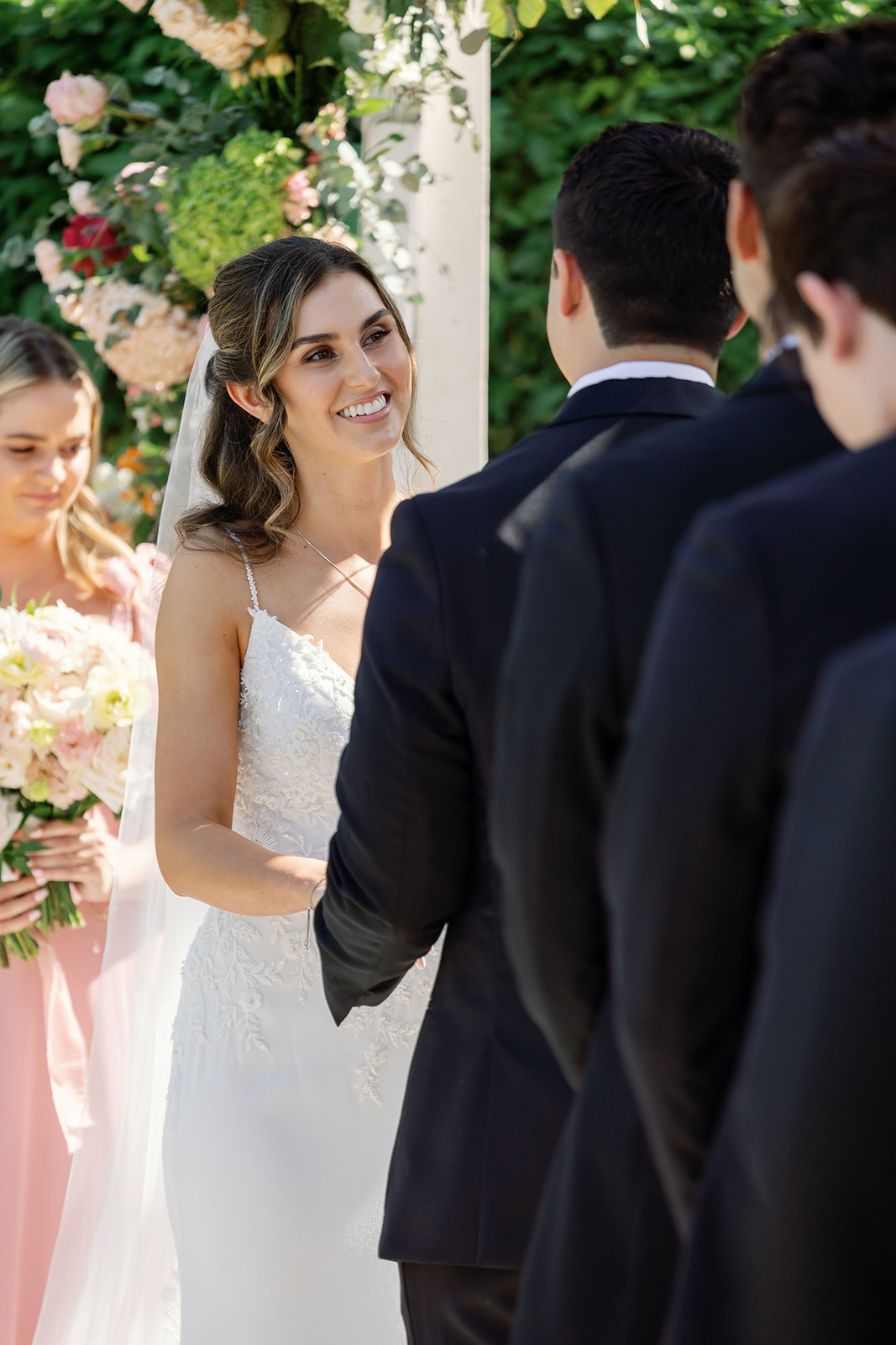 Bride smiling at the groom during their Hyatt Regency Newport Beach Amphitheater wedding ceremony.