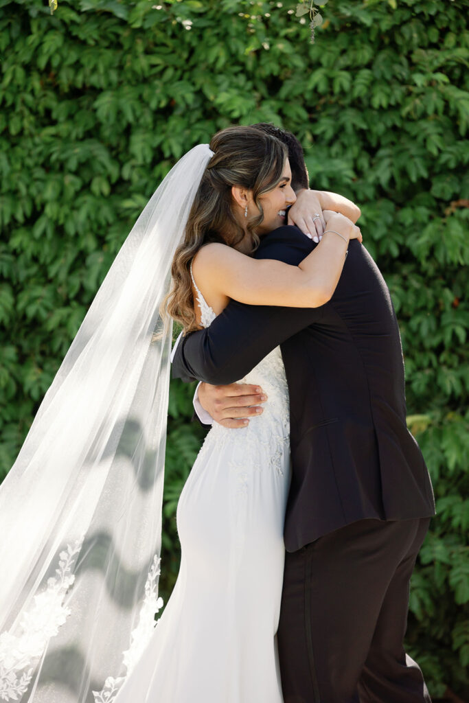 Newly married couple hugging after their ceremony in the Amphitheater.