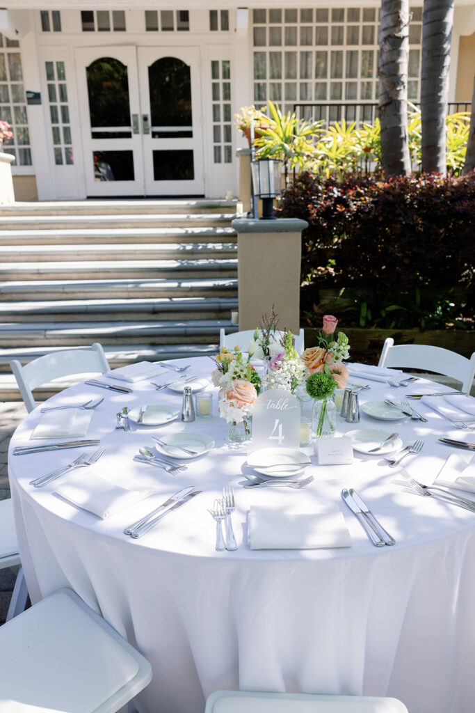 Outdoor wedding table with peach, orange, cream, and green floral centerpieces at Hyatt Regency Newport Beach.