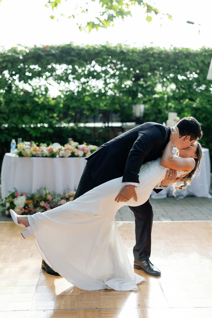 Groom dipping his bride during their first dance at Hyatt Regency Newport Beach in the garden.