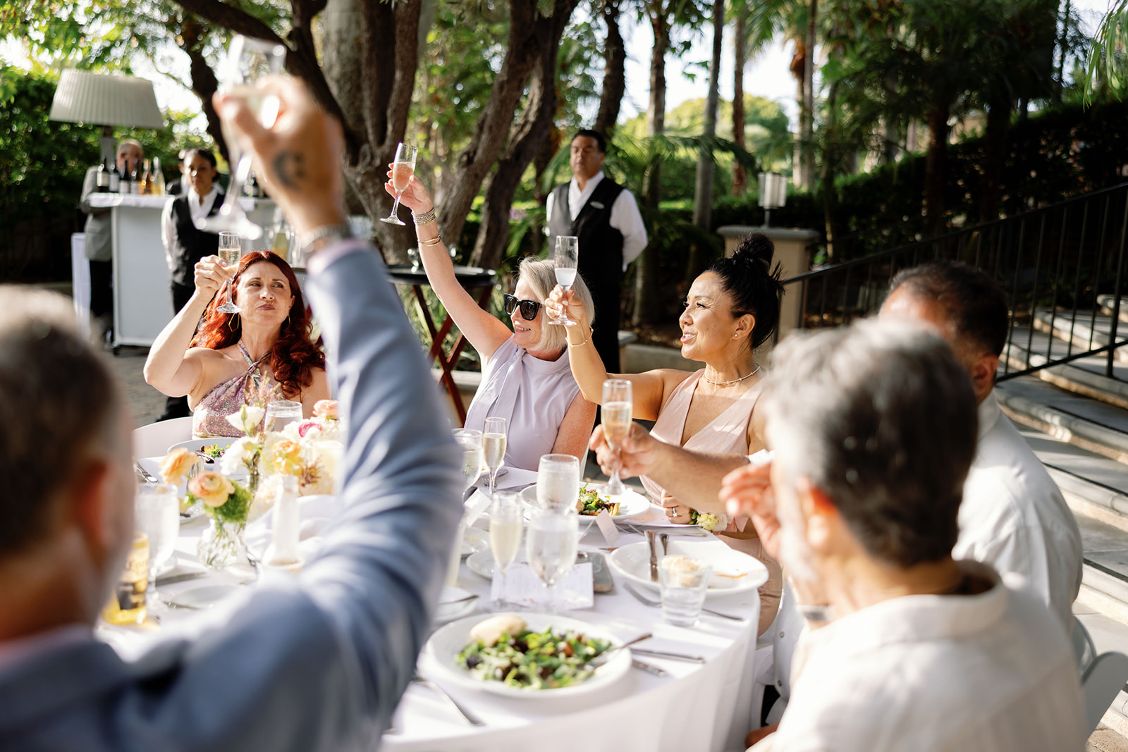 Guests raising their drinks during speeches for a Hyatt Regency Newport Beach wedding reception in the Garden.