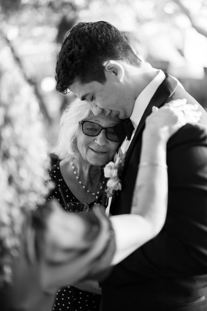 Groom hugging a family member during the reception.