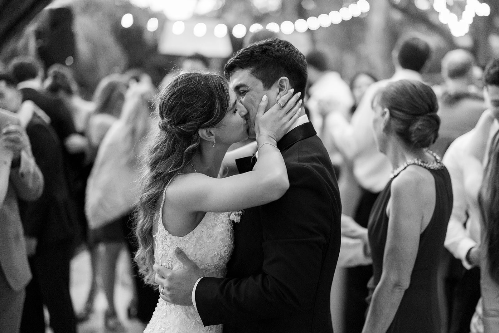 Couple kissing on a crowded dance floor during their Garden wedding reception.