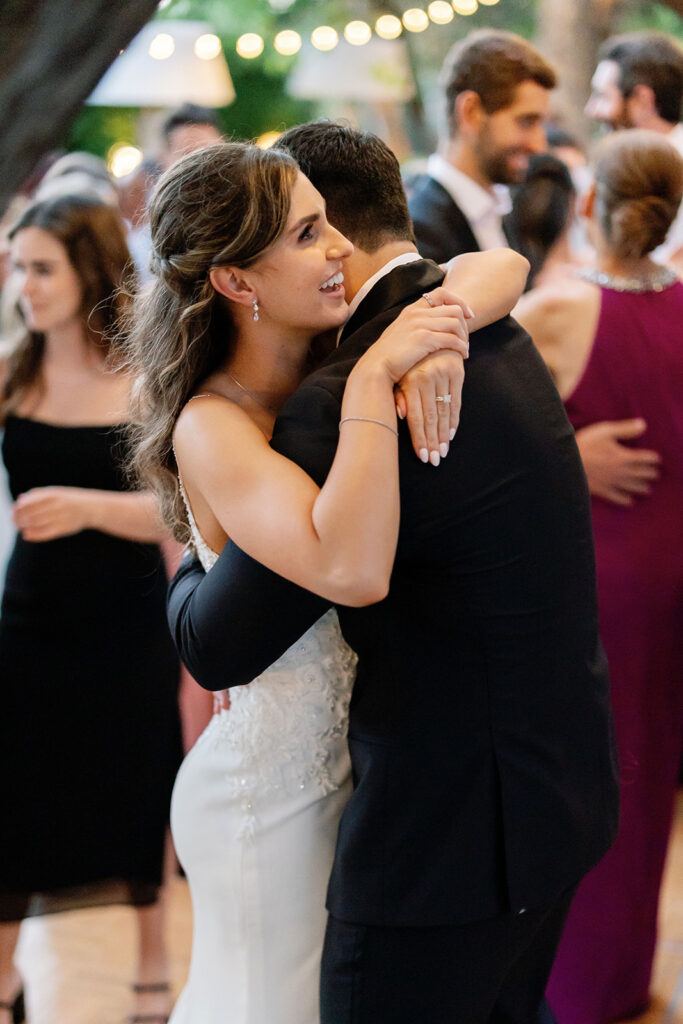 Bride and groom hugging as they dance on the dance floor.