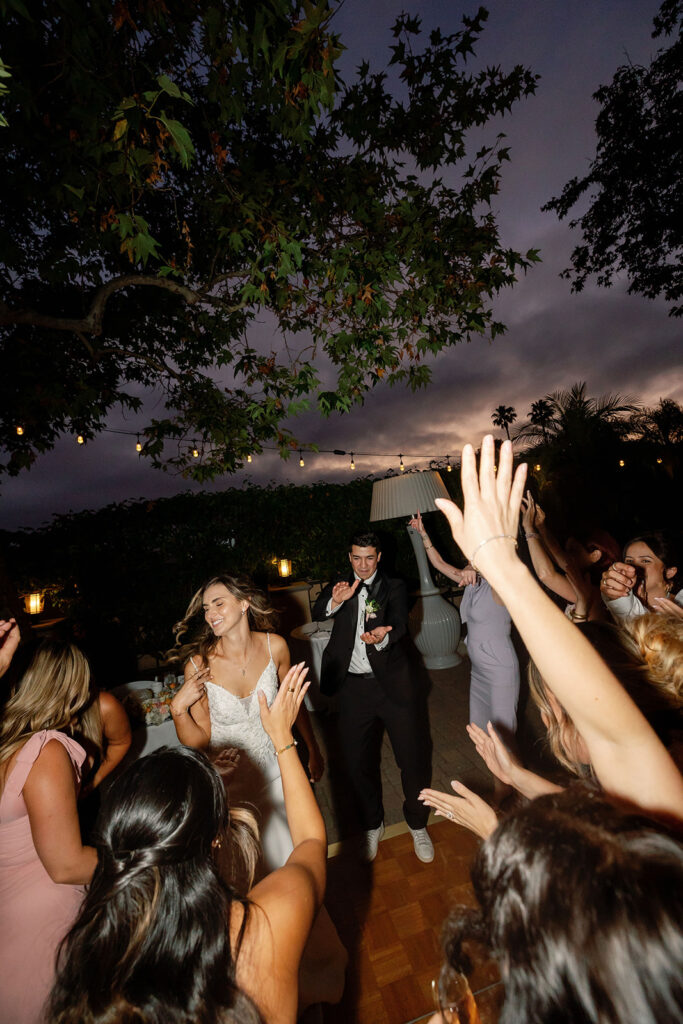 Couple dancing with friends during their outdoor Garden wedding reception.