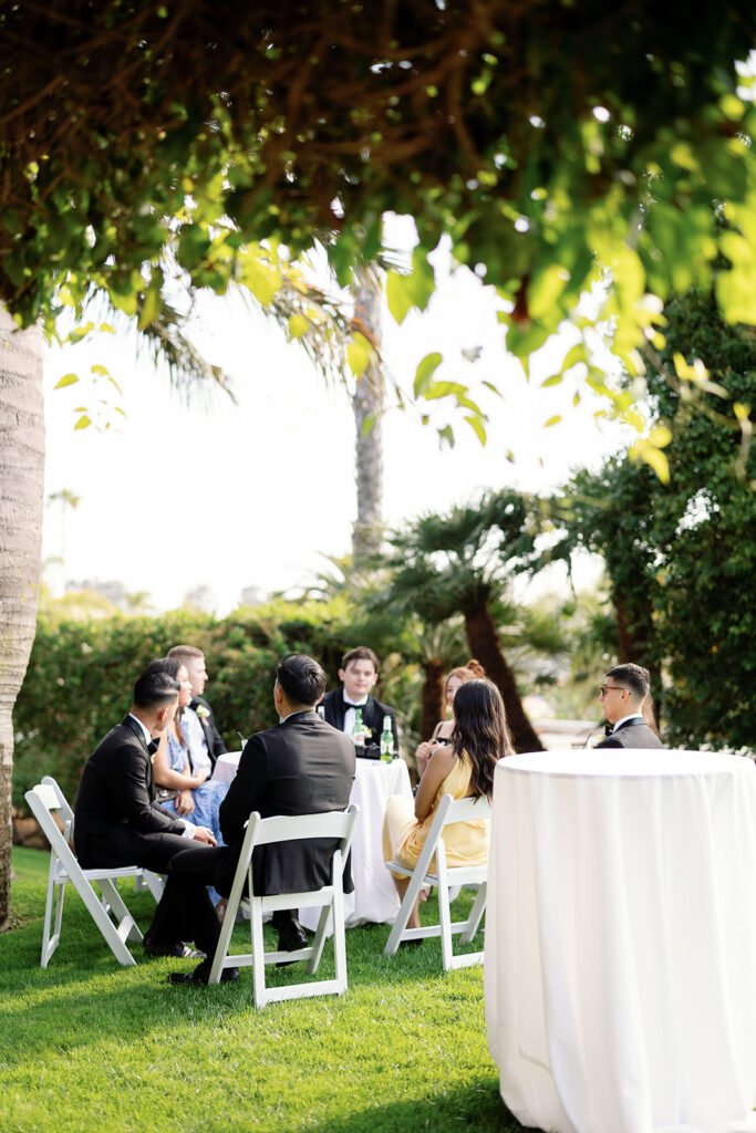 Wedding guests gathered around cocktail tables on the lawn near the Amphitheater.