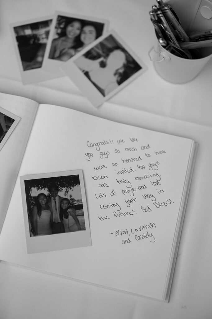 Polaroid photos and a handwritten message displayed inside the couple’s wedding guest book.
